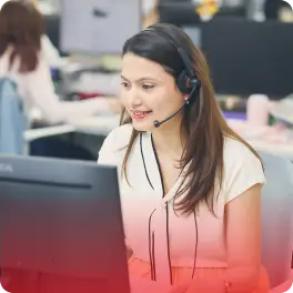 ヘッドセットを装着しモニターを見ながら笑顔で業務に取り組む女性社員